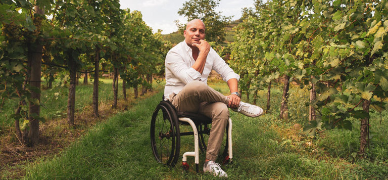 Der Wachau Insider sitzt im Rollstuhl im Weingarten.