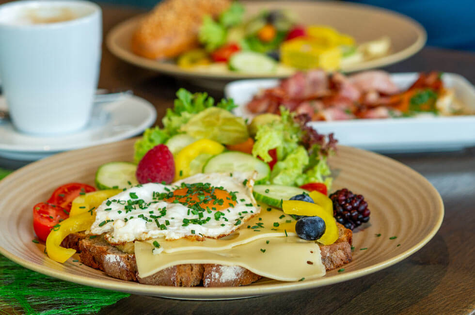 Angerichtetes Frühstück mit Spiegelei, frischen Beeren und Gemüse.