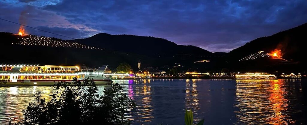 Sonnwendfeier in der Wachau mit Blick auf die leuchtenden Weinberge.
