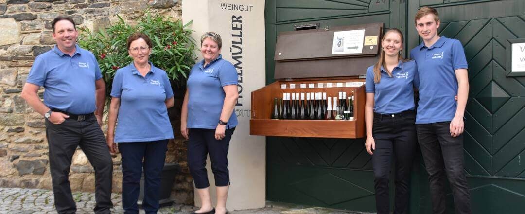 Familie Höllmüller sitzt im Sommer unter der schattigen Laube im gemütlichen Heurigenlokal direkt beim Hauptplatz von Spitz in der Wachau.