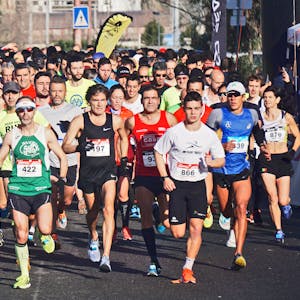 A large group of marathon runners competes outdoors in broad daylight, showcasing endurance and fitness.